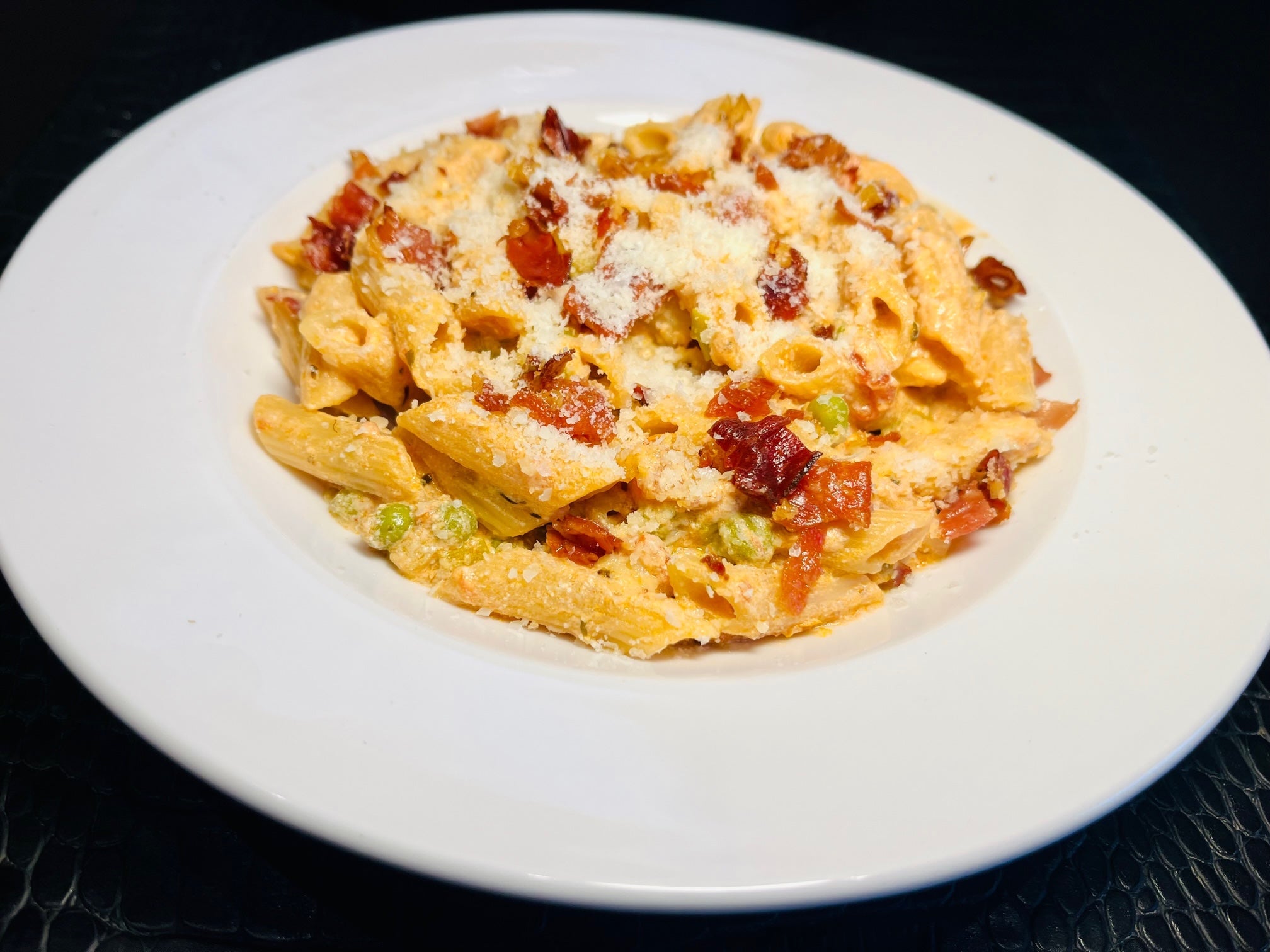 Pasta mit Erbsen, Ricotta, Südtiroler Bauernspeck und Tomatensauce